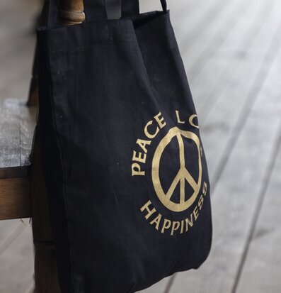 Väska Canvas Peace från Different Design på en trästol