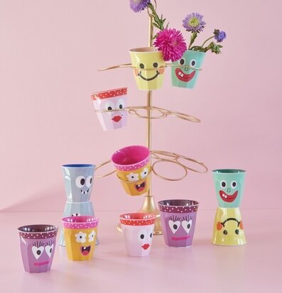 Foto av färgglada muggar med blommor på displayställning