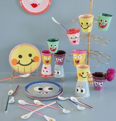 Foto av färgglada muggar och tallrikar med ansikten