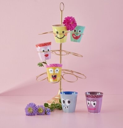 Bild av lekfulla muggar med ansiktsuttryck i träställ