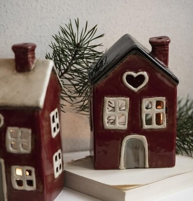 Bild av ljuslyktor i form av röda hus med grankvistar