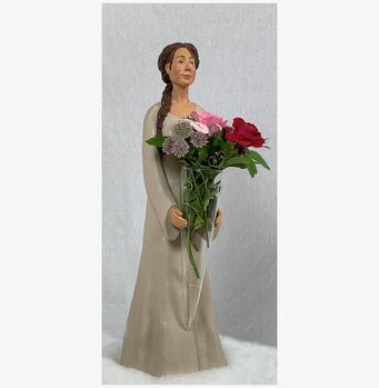 Figurin Katarina från Sverigealmanackan med blommor i vas