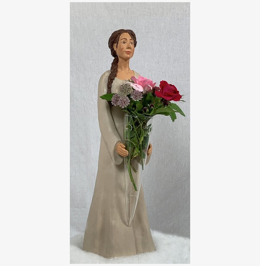 Figurin Katarina från Sverigealmanackan med blommor i vas