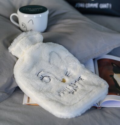 Bild av mysig vit värmeflaska med kattbroderi