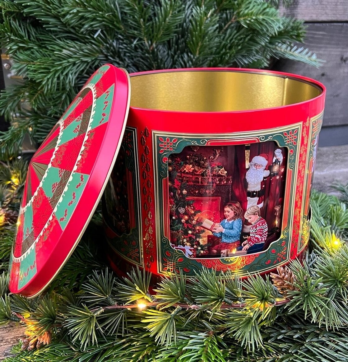 Bild av nostalgisk plåtburk med julmotiv och dekorationer