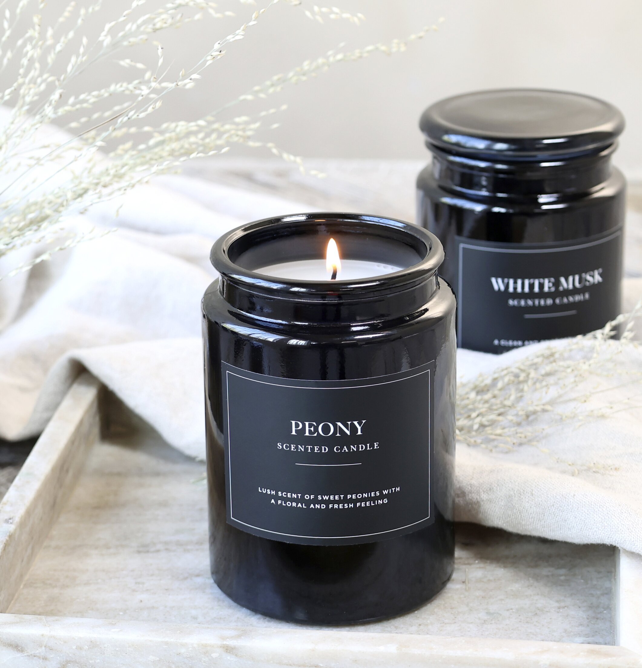 Doftljus Peony från Chic Antique i mörkt glas på träbricka