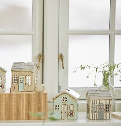 Bild av harmonisk inredning med miniatyrhus och växter