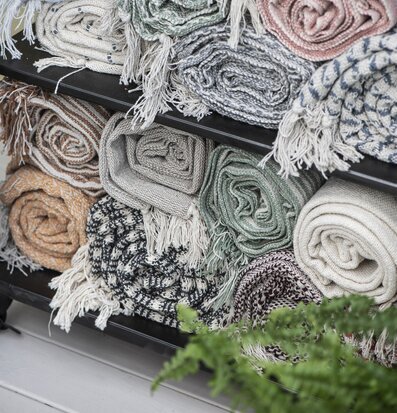 Pläd Creme/Blå från IB Laursen på hylla med dekorationer