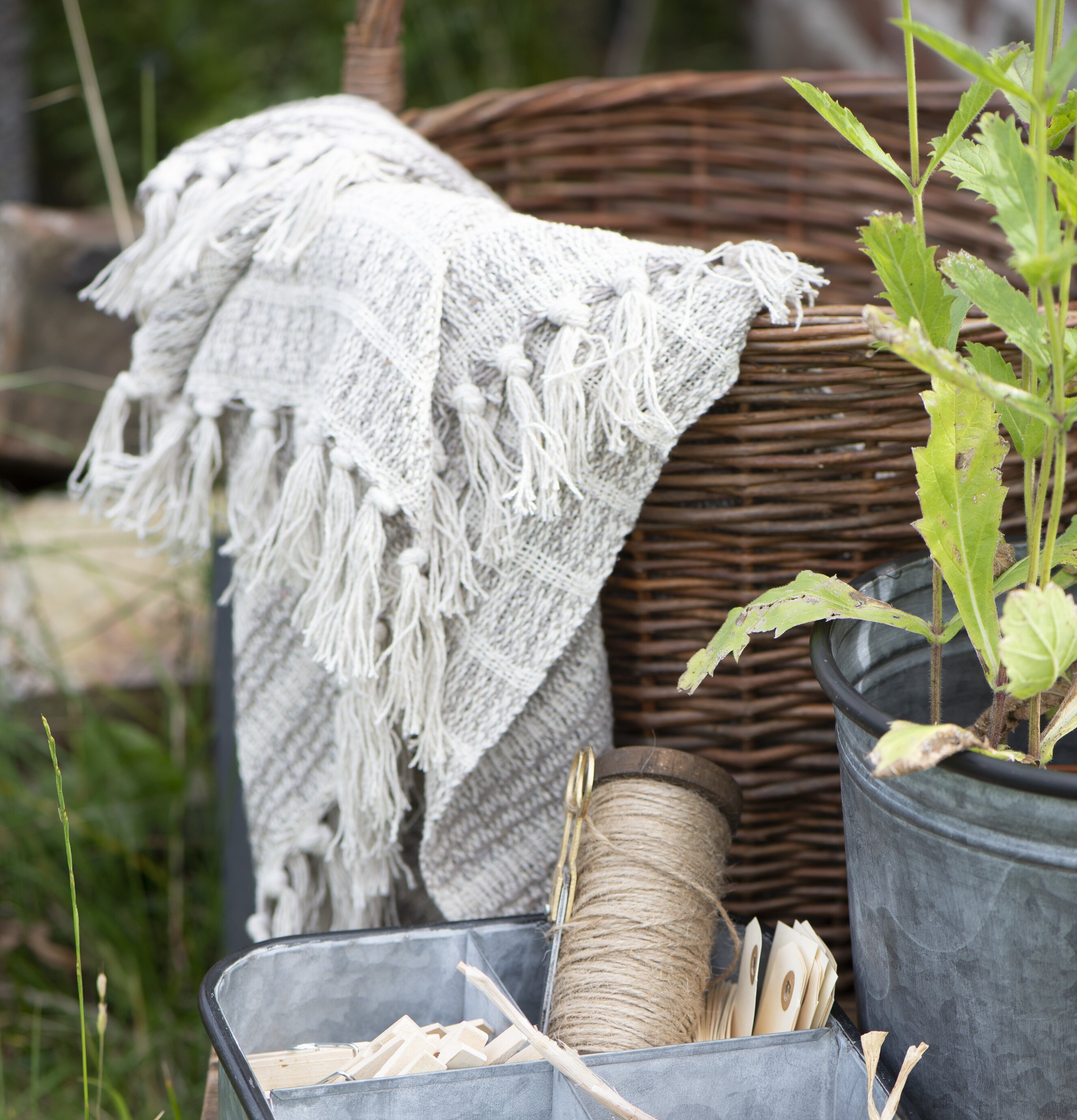 Pläd Creme/Natur från IB Laursen med fransar på en korg