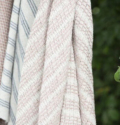 Pläd Creme/Malva från IB Laursen i en grönskande miljö