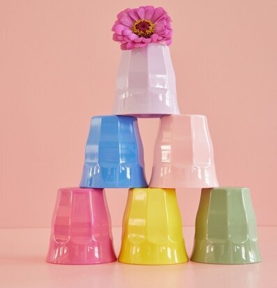 Bild av färgglada muggar i pyramidform mot rosa bakgrund