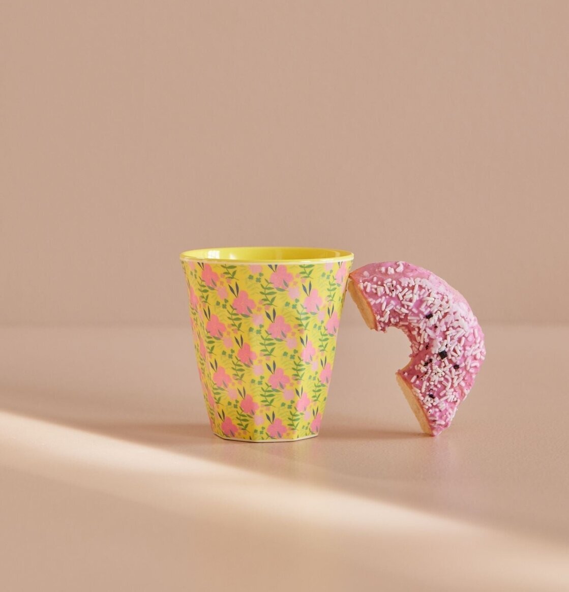 Bild av melaminmugg med färgglada blommor och donut