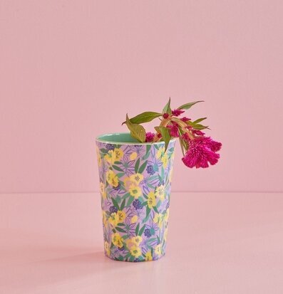 Foto av färgglad mugg med blommönster och rosa bakgrund