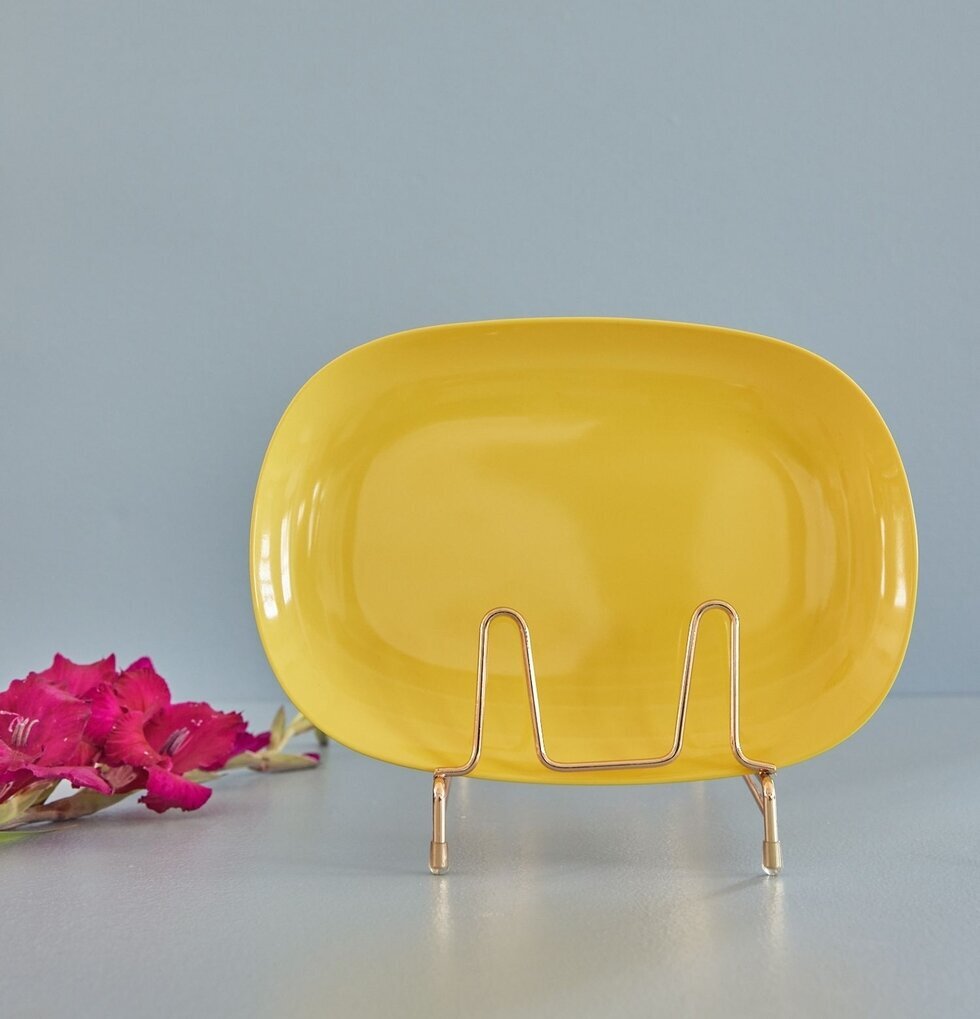 Tallrik Large Yellow från Rice på guldställ med grå bakgrund