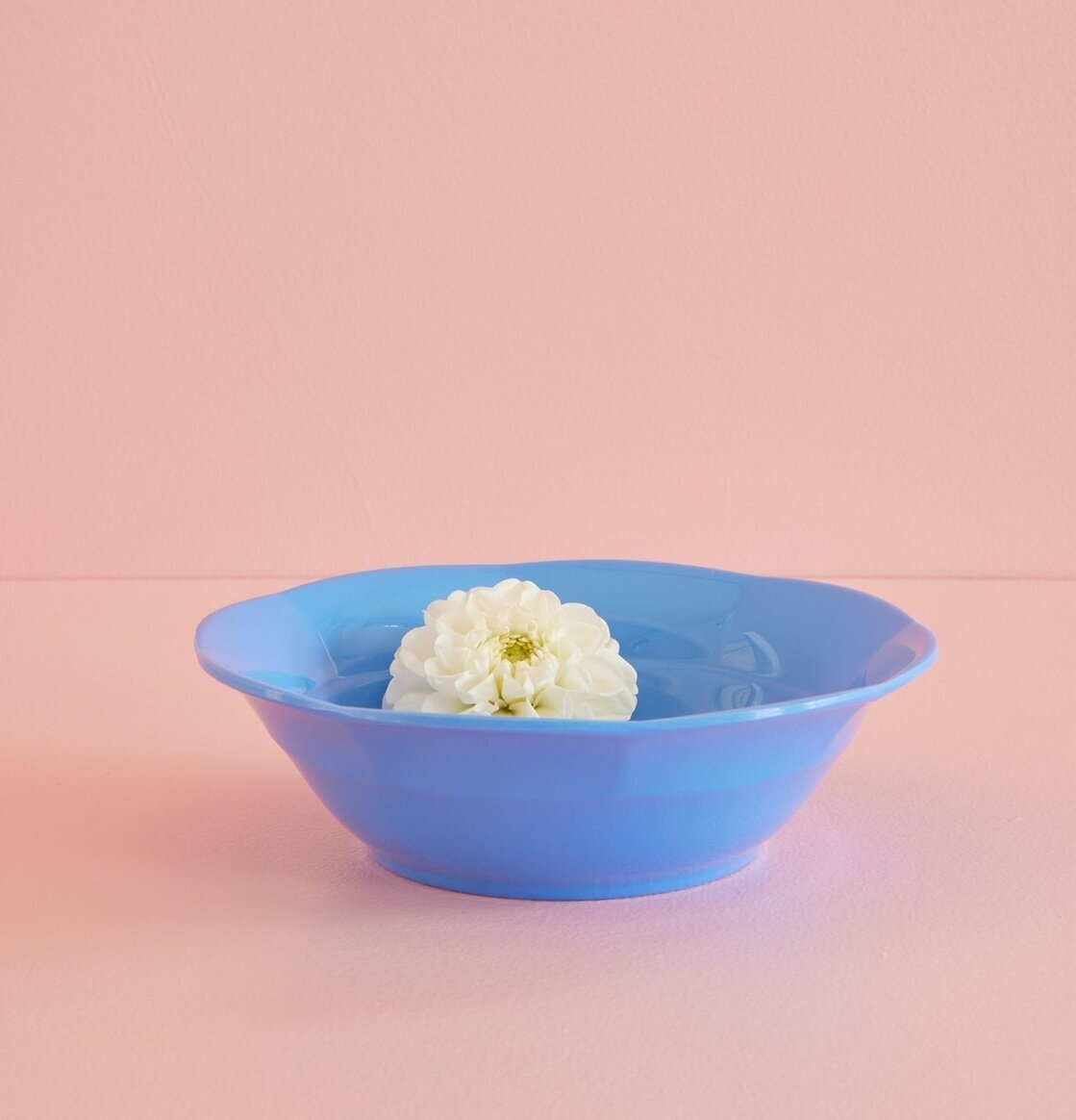 Djup Tallrik Sky Blue från Rice med vit blomma i rosa miljö