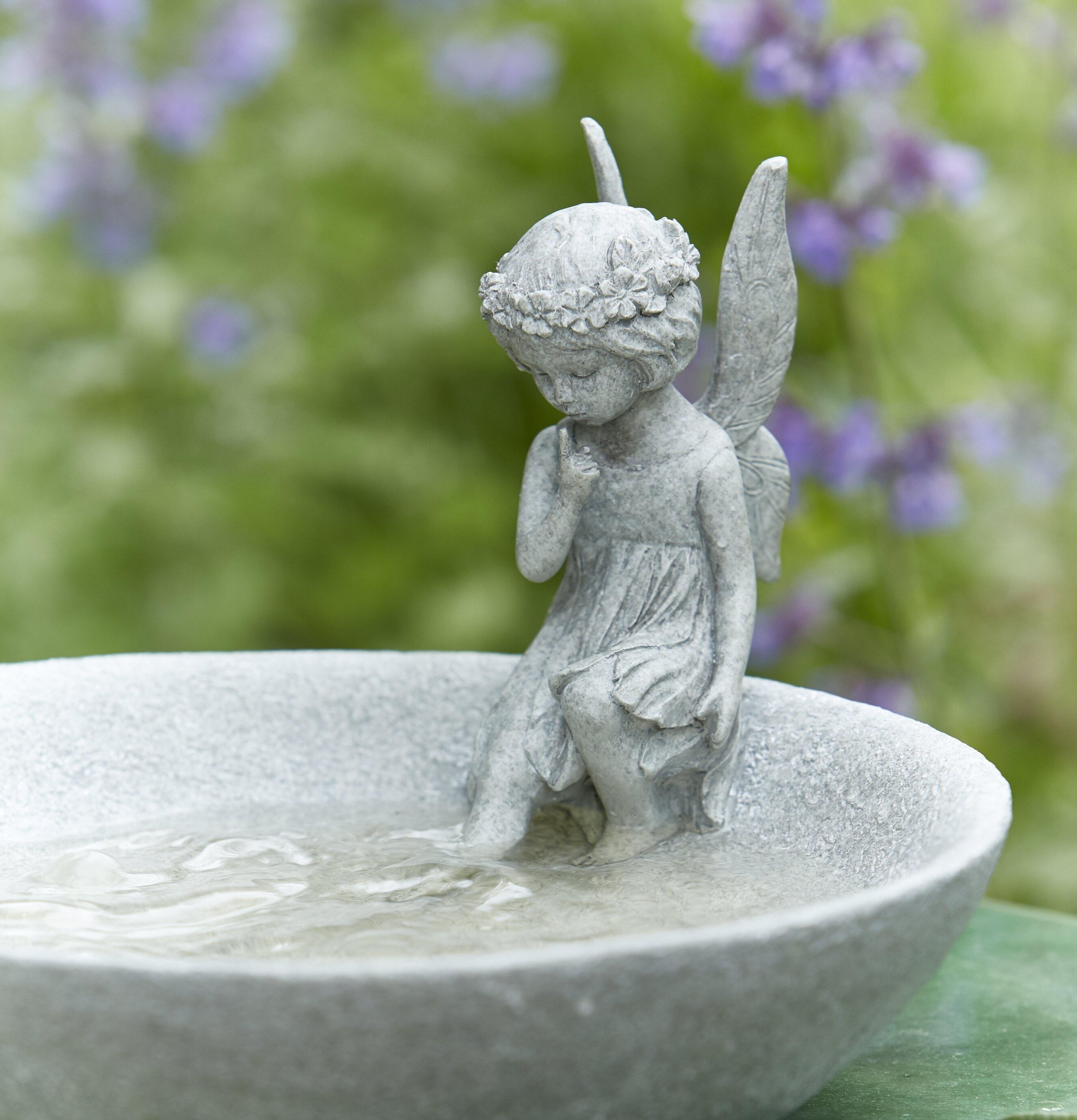 Fågelbad Tingeling från Wikholm Form i en frodig trädgård