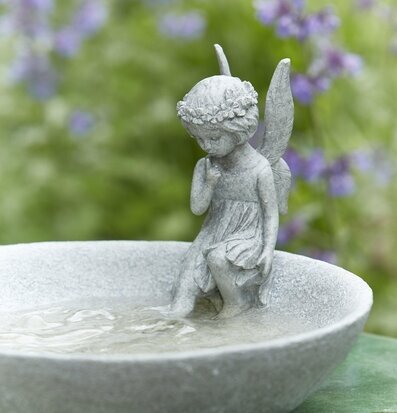 Fågelbad Tingeling från Wikholm Form i en frodig trädgård