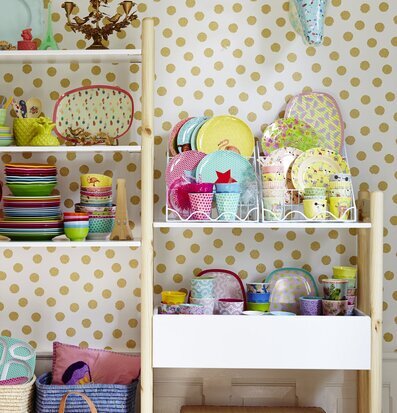 Ljusstake Guld från Rice på vit hylla med guldprickig tapet