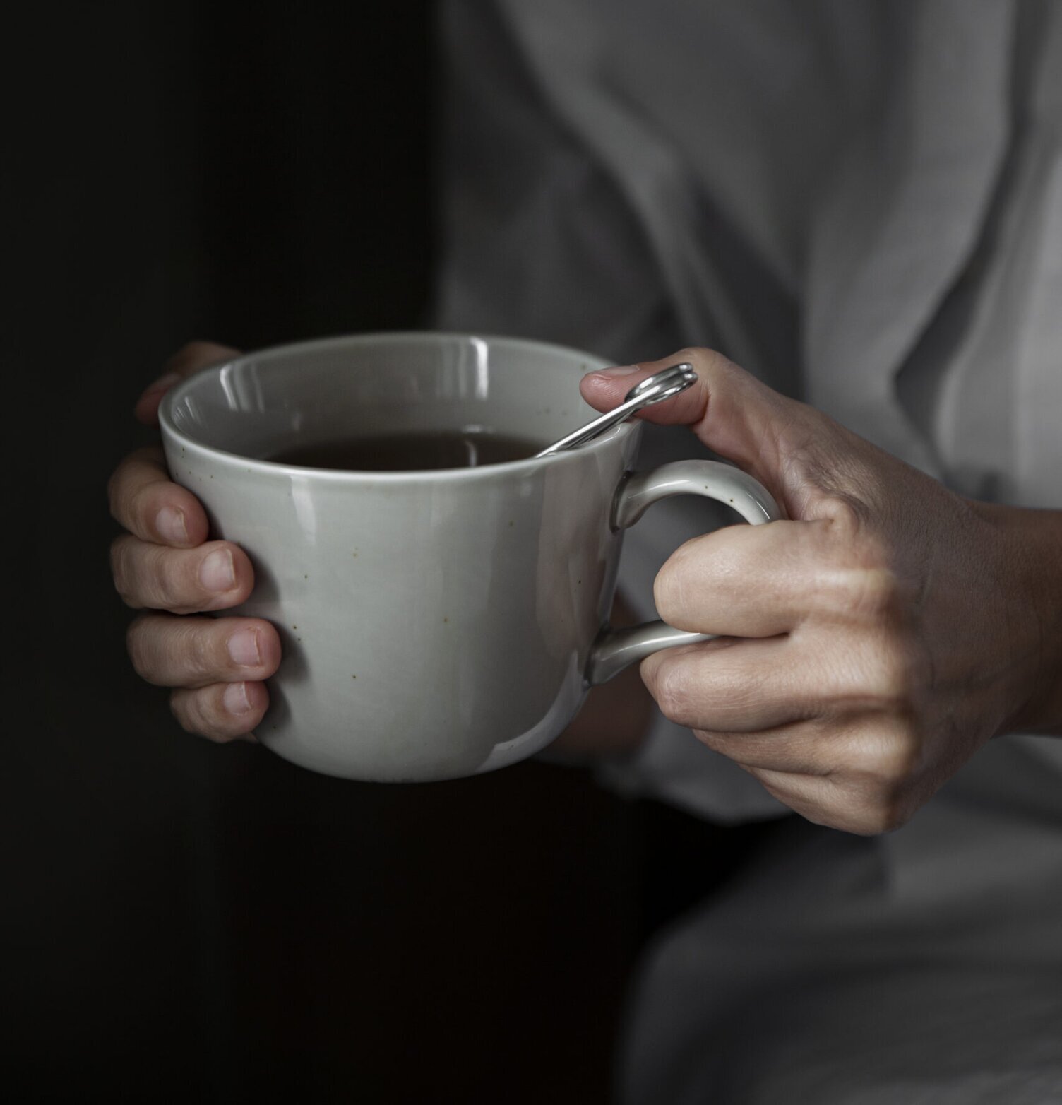 Tekopp Porslin Sand - Ernst hålls i händer, vit skjorta