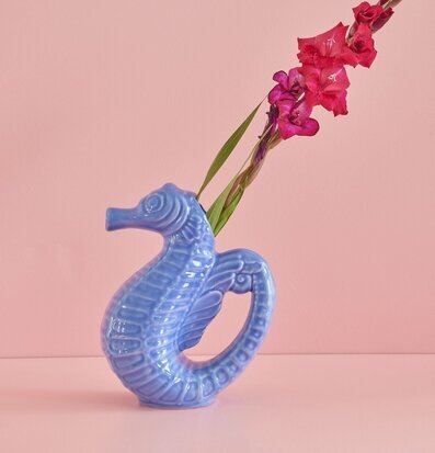 Kanna Sjöhäst Blå från Rice på rosa yta med röda blommor