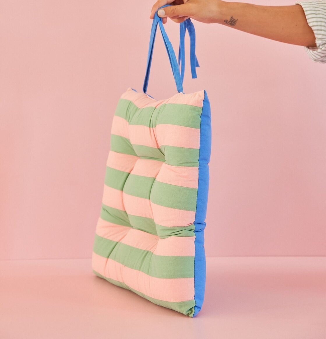 Stolsdyna Striped Print Pink/Green från Rice hålls upp av hand