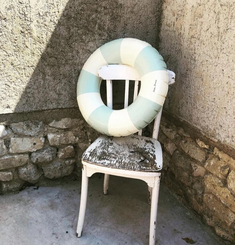 Badring Calile - Petites Pommes på sliten stol i stenmiljö