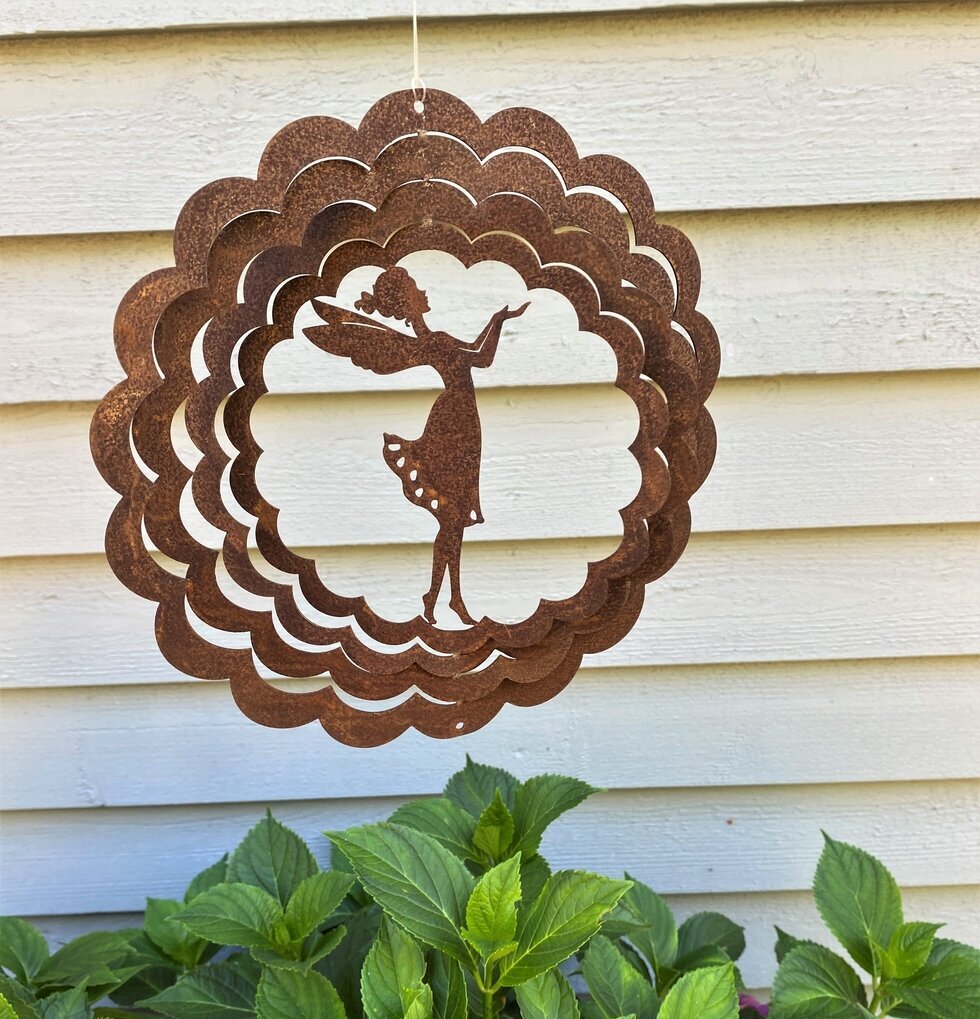 Vindspel Älva Rost från Lind Decoration i en trädgårdsmiljö