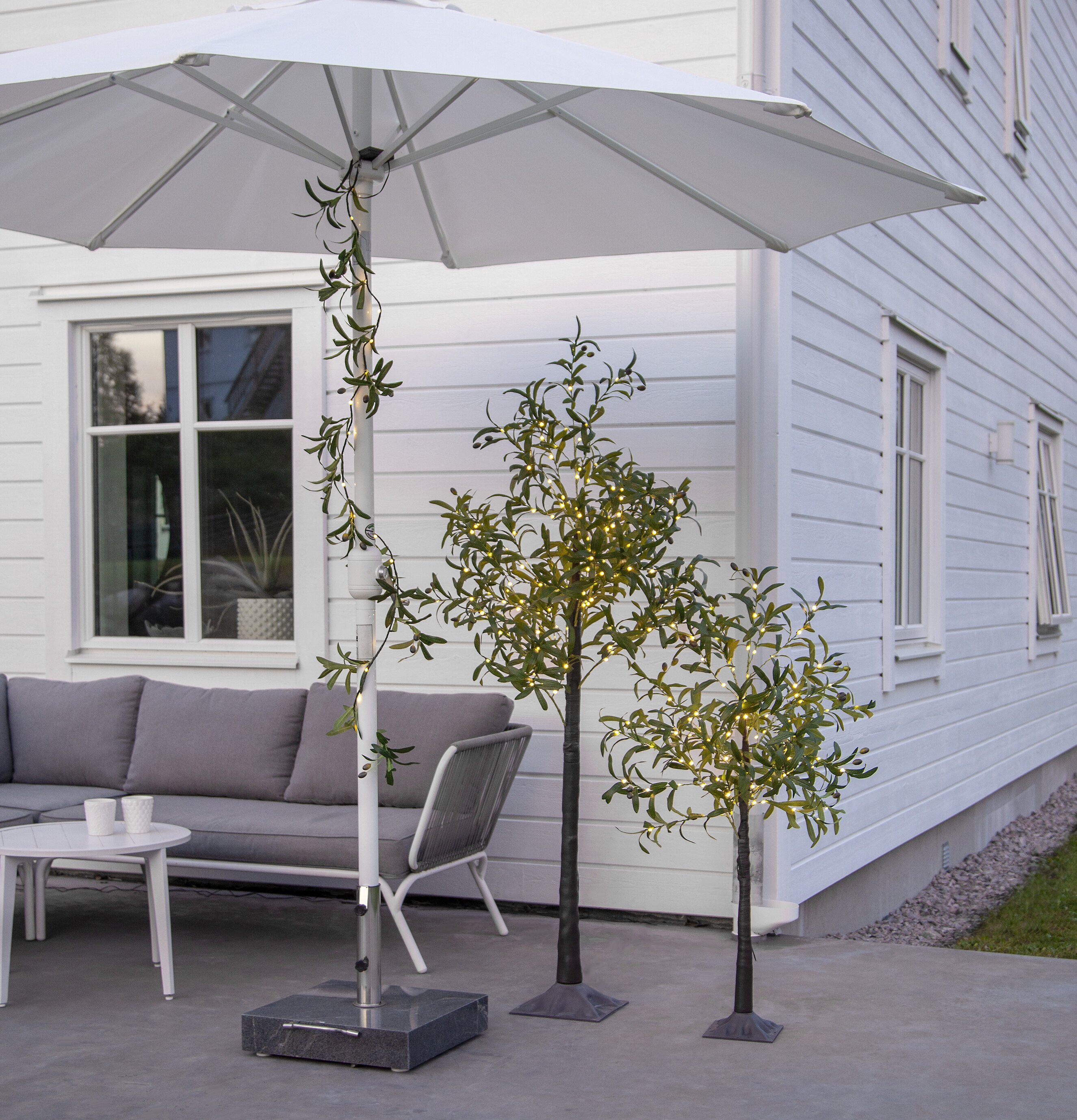 Girlang Olivec från Star Trading virad runt vit parasollstång