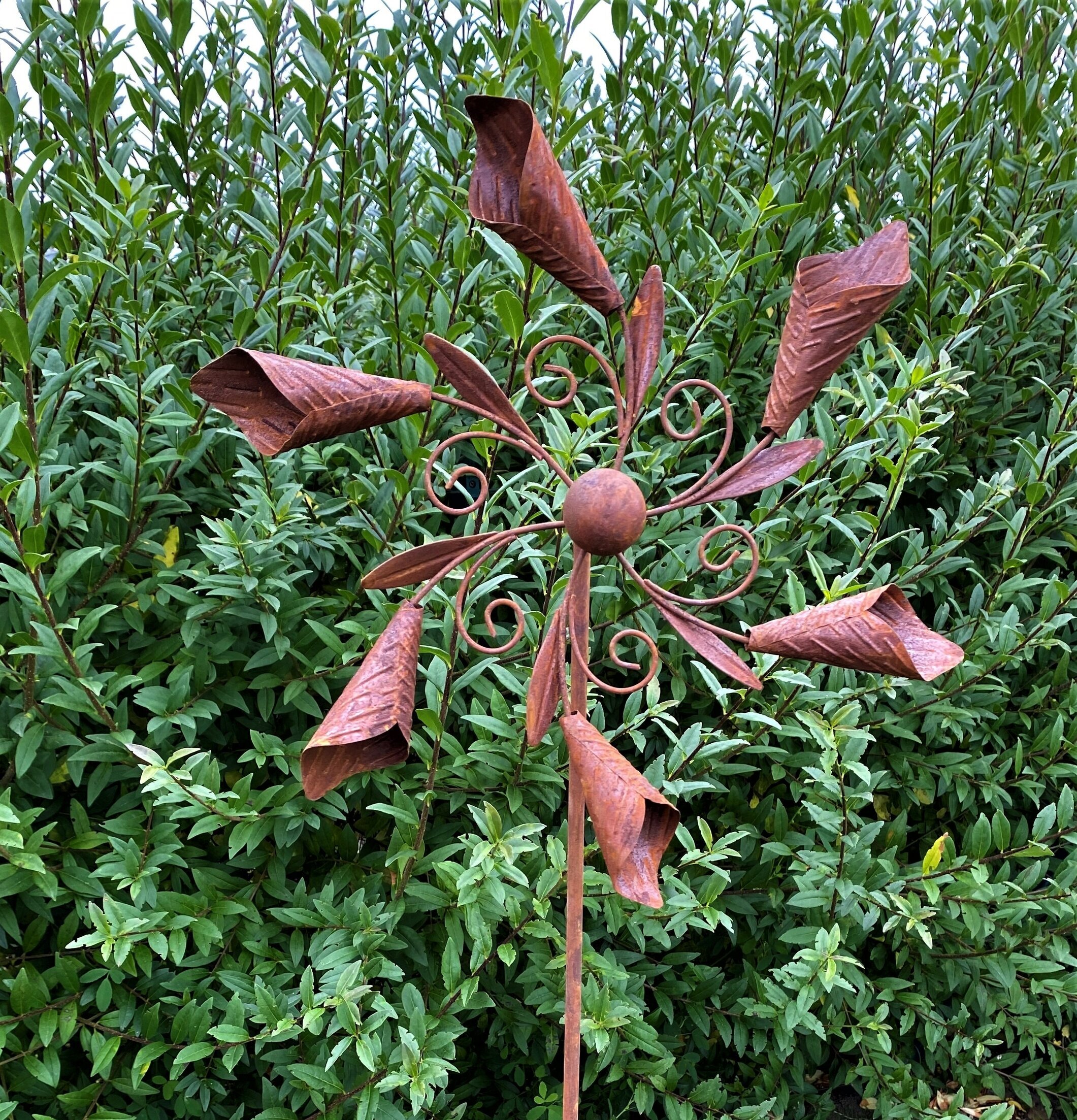Vindsnurra Kalla Rost från Lind Decoration i lummig trädgård