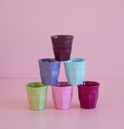 Foto av färgglada muggar i pyramidform mot rosa bakgrund