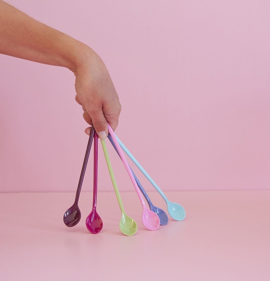 Långa Skedar - Via La Vida från Rice hållna mot rosa bakgrund