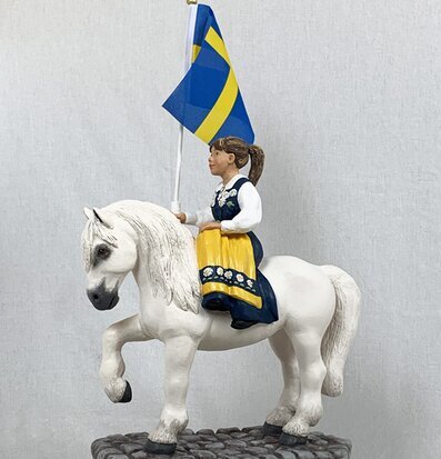 Sverigehästen från Sverigealmanackan med flicka i folkdräkt