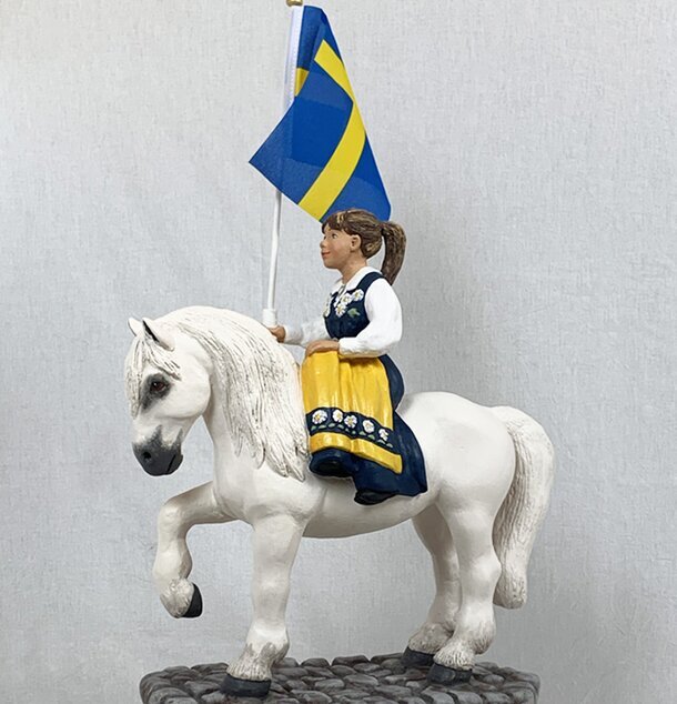 Sverigehästen från Sverigealmanackan med flicka i folkdräkt