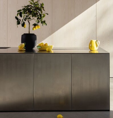 Kanna Lemon från By ON på rostfri köksö med citroner