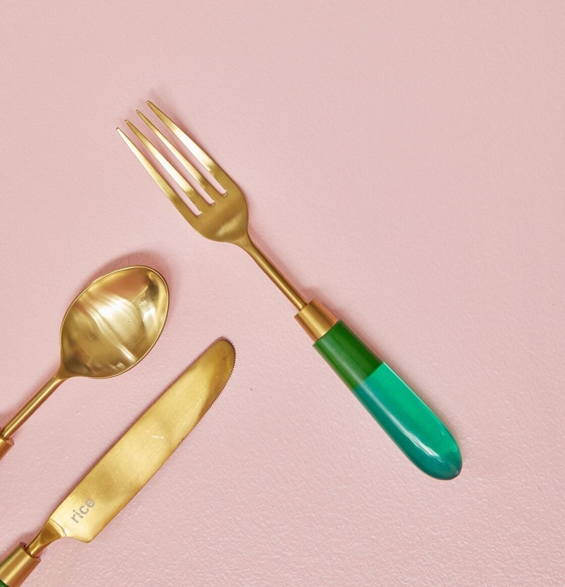 Mässingsbestick Gaffel Grön från Rice mot rosa bakgrund