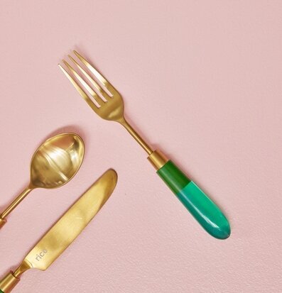Mässingsbestick Gaffel Grön från Rice mot rosa bakgrund
