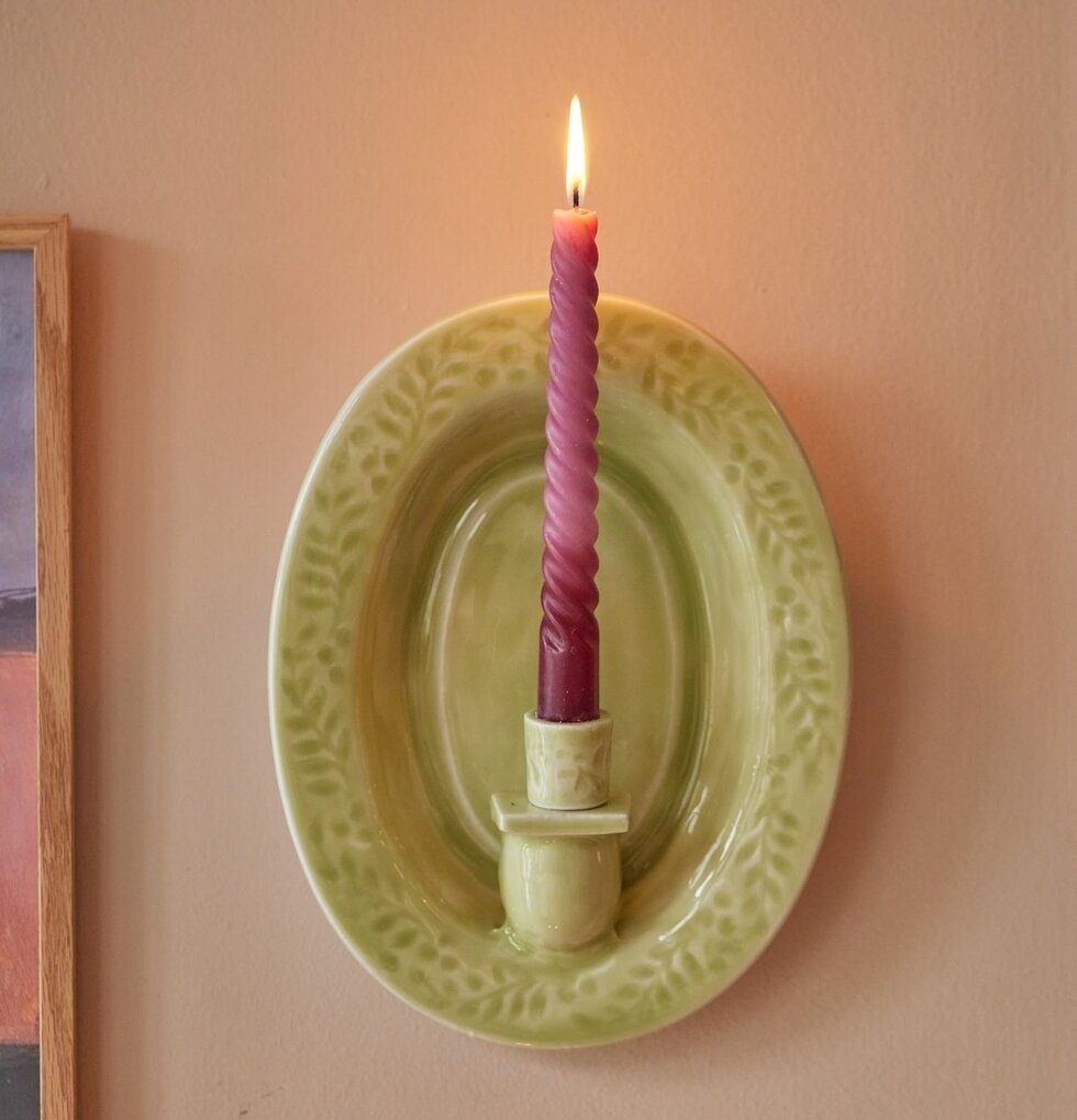 Väggljusstake Grön från Rice på neutral vägg med ljus