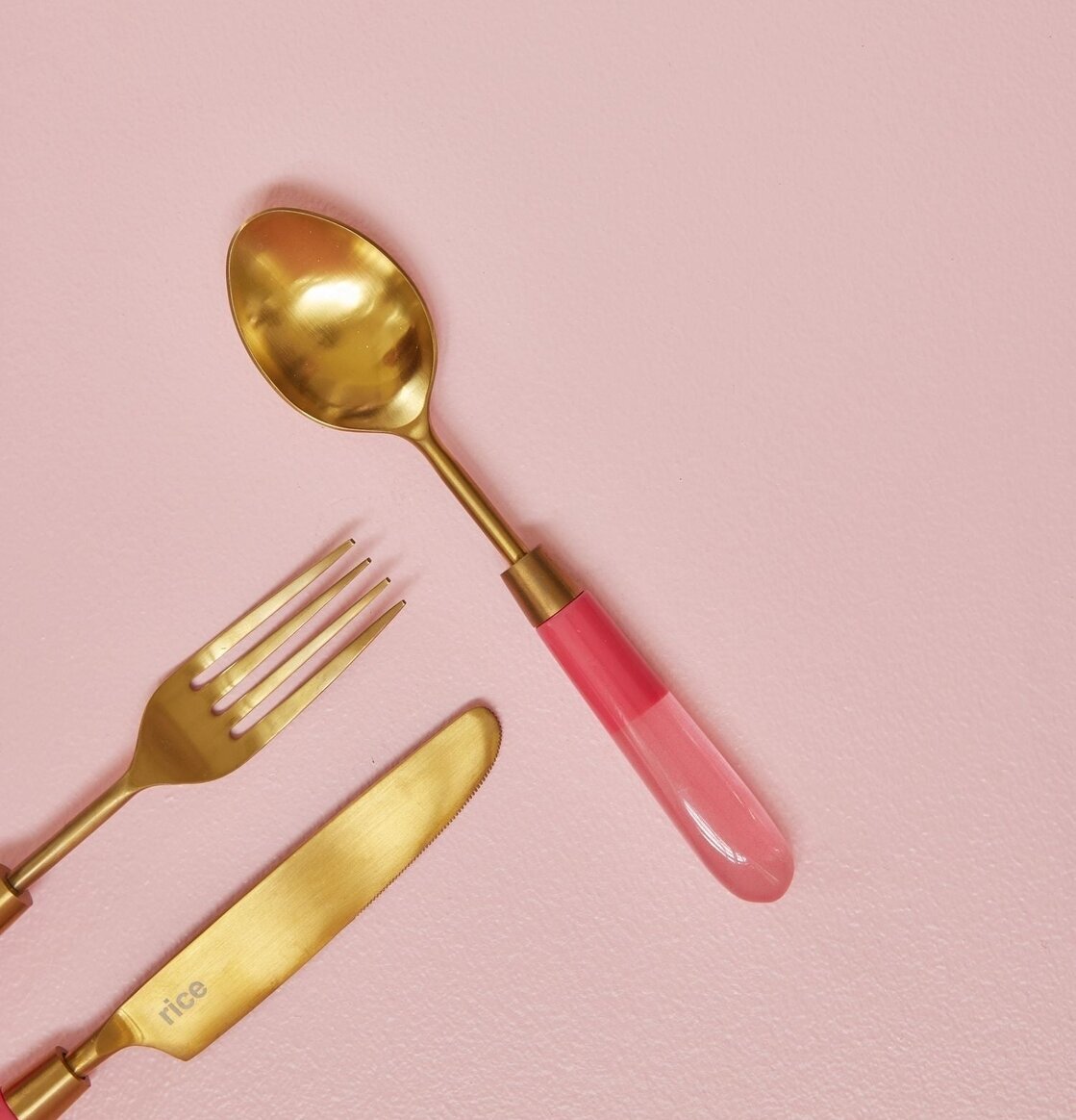 Mässingsbestick Sked Rosa från Rice på rosa bakgrund