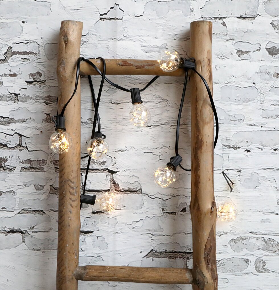 Ljusslinga LED från Chic Antique draperad över trästege