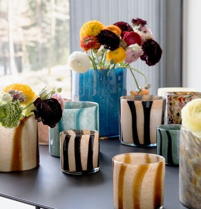 Bild med ljuslyktor och färgglada blommor i harmoni