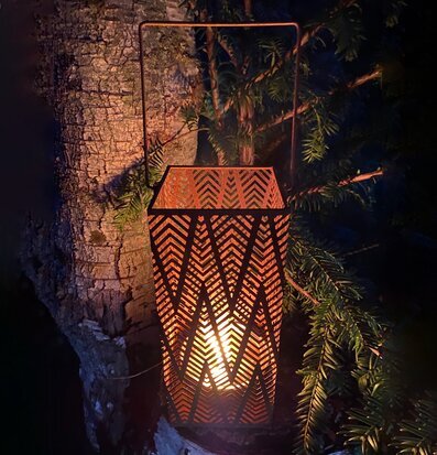 Bild av en roströd lykta i naturskön miljö