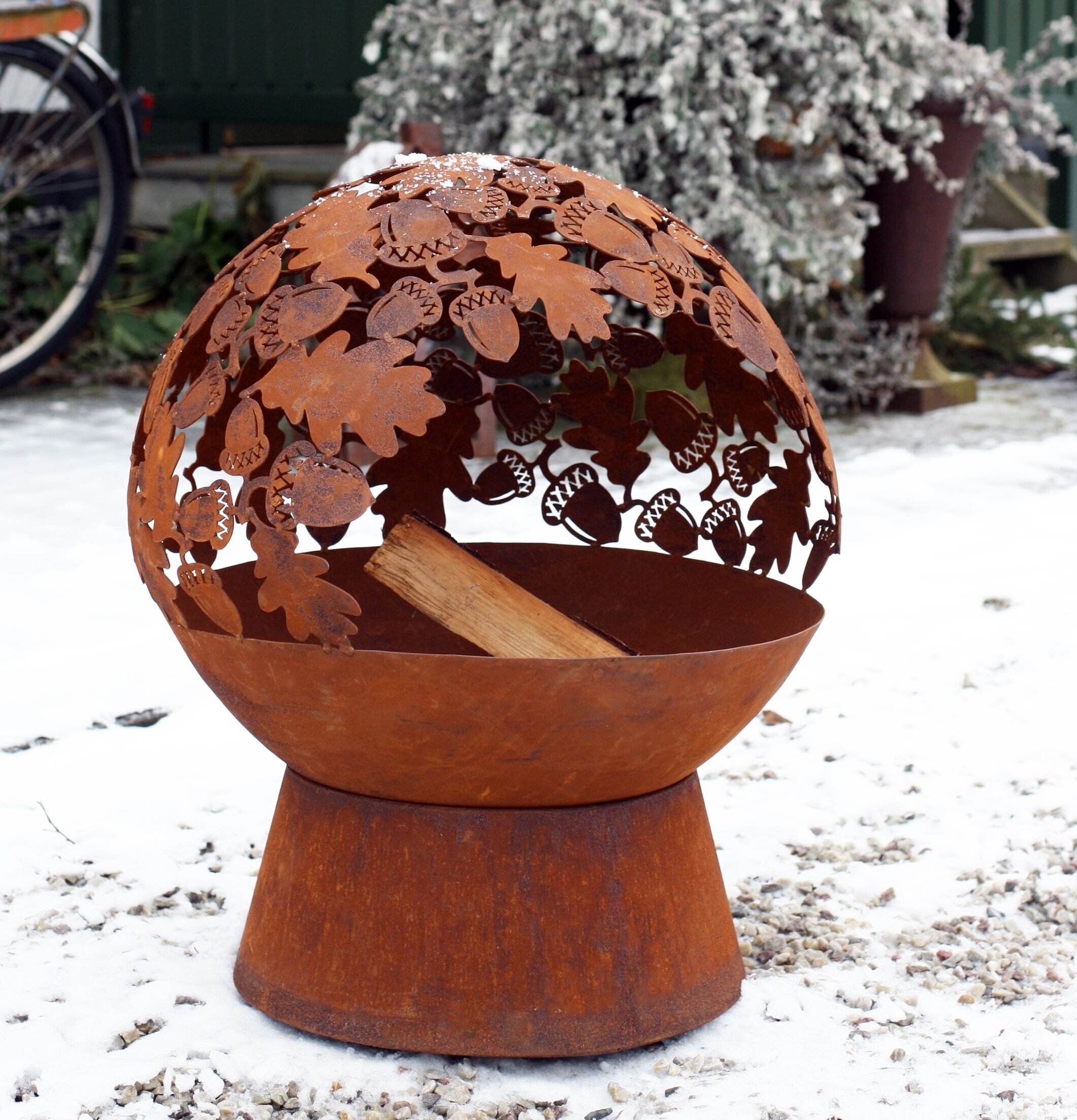 Eldklot Rost från Västanvinden i vinterträdgård med cykel