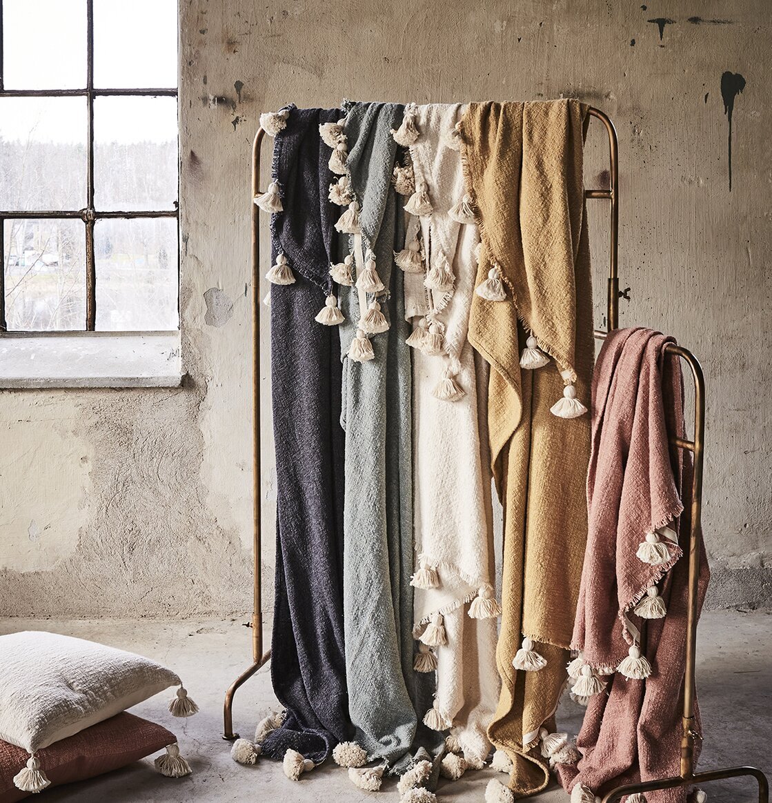 Pläd Lolly Korall/Beige från Affari på metallställ i rum