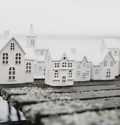 Bild av vita ljusstakar formade som hus på träbänk