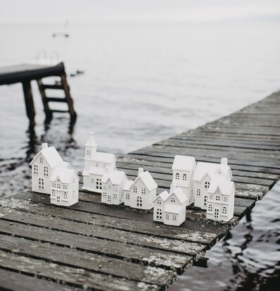 Bild av stilrena vita ljusstakar på väderbiten brygga