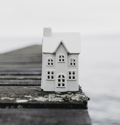 Bild av vit ljusstake på träbrygga med vatten i bakgrunden