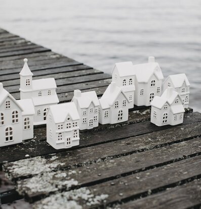 Bild av dekorativa ljusstakar på träbrygga vid sjö