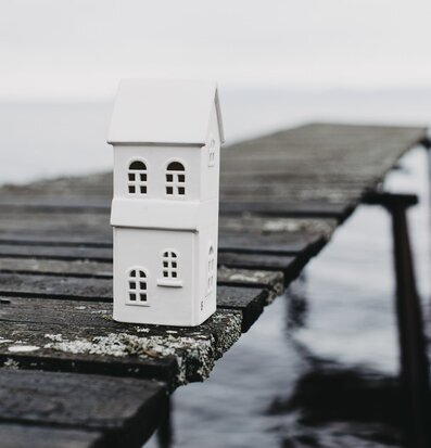 Foto av vit ljusstake på gammal träbrygga vid vatten