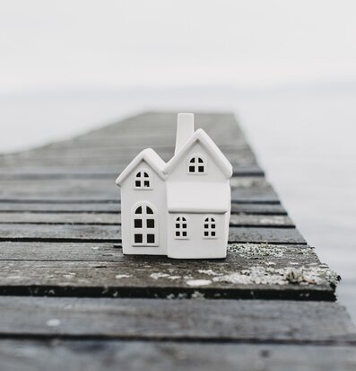 Bild av ljusstake formad som hus vid sjölandskap