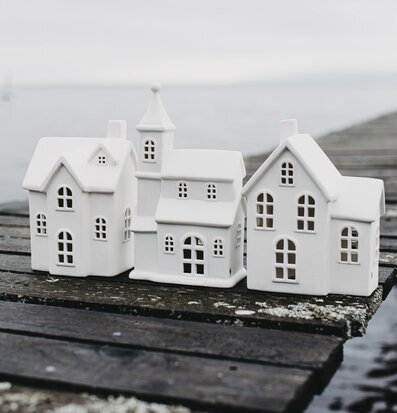 Bild av keramiska ljusstakar på träbrygga vid vatten